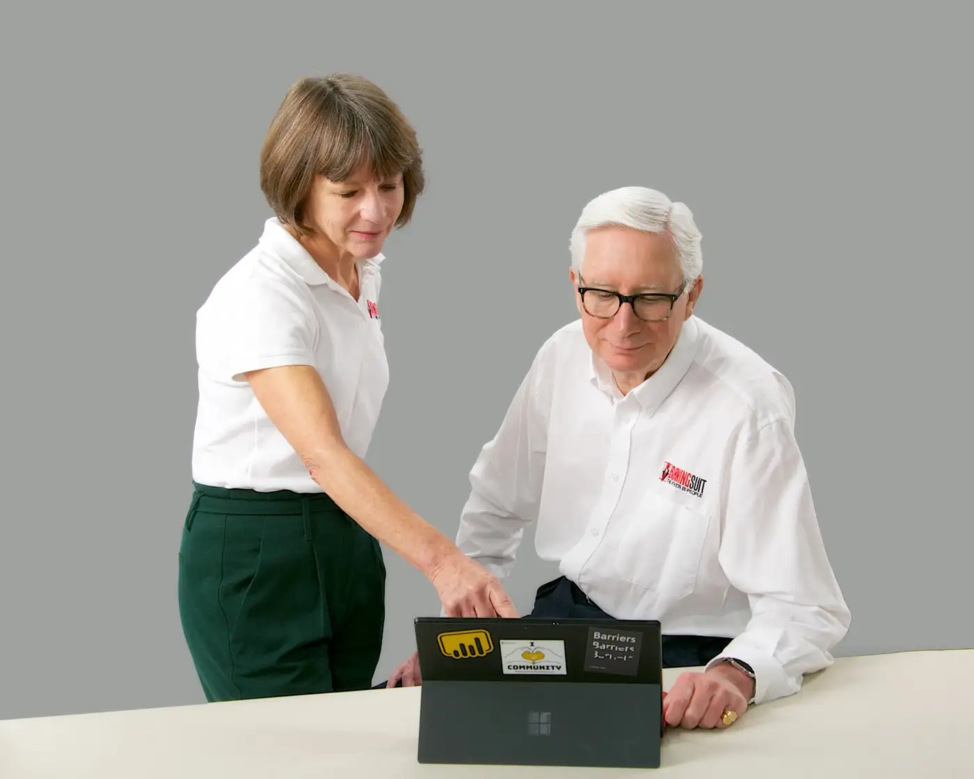 Stuart and Alison, who ran burningsuit before Alan, at a laptop together - Alison pointing at the screen